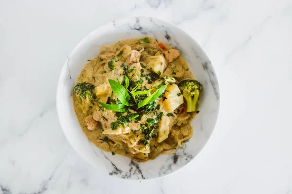 stock image plant-based spicy sweet potato and broccoli curry with vermicelli noodles, healthy vegan food recipes