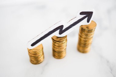 Artan para yığınları ve yukarı bakan ok, birikimlerinizi ve bileşik çıkarlarınızı artırma metaforu