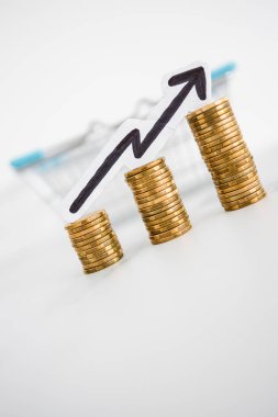 Fiyatlar yükseliyor ve artan enflasyon kavramsal imaj ile alışveriş sepeti ve artan oklu madeni para yığınları