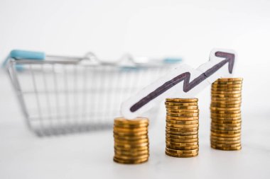 Fiyatlar yükseliyor ve artan enflasyon kavramsal imaj ile alışveriş sepeti ve artan oklu madeni para yığınları