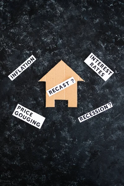 house with recast text surrounded by concepts like interest rates inflation recession and price gouging, worldwide economic issues after the pandemic