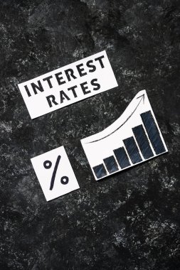 Faiz oranları metni yüzdelik sembol ve istatistiklerle birlikte koyu arka planda artar, salgından sonra ekonomik mücadele kavramı