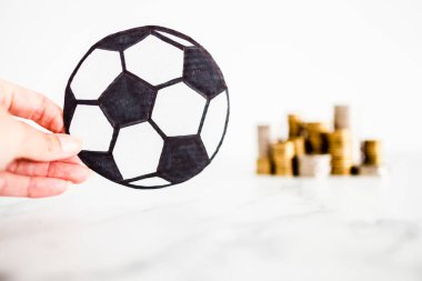 Arka planda para yığınları olan futbol topu, para ve spor endüstrisi kavramı