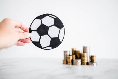 Arka planda para yığınları olan futbol topu, para ve spor endüstrisi kavramı