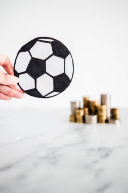 Arka planda para yığınları olan futbol topu, para ve spor endüstrisi kavramı