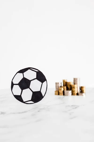 stock image soccer ball with stacks of coins in the background, concept of money and sport industry