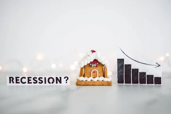 cost of living and interest rates rising around Christmas 2022, recession graph with stats going up next to gingerbread house and fairy lights in the background