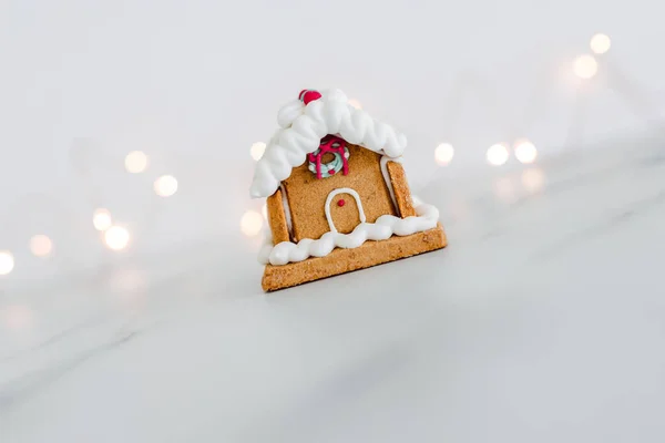 Festliche Weihnachts Lebkuchenhaus Mit Feenbeleuchtung Hintergrund Auf White Minimalistische Komposition — Stockfoto