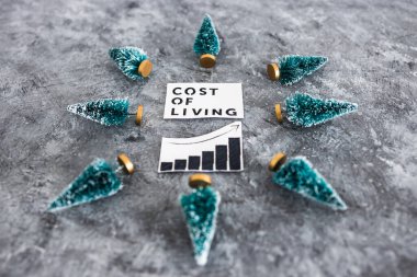 Cost of Living graph with stats going up surrounded by mini Christmas trees, concept of inflation rising during the 2022 festive season clipart