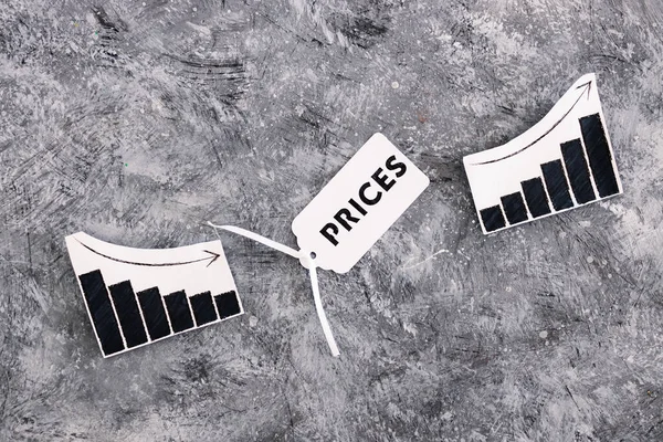 Stock image inflation and price hikes conceptual image, Prices text on product tag next to graph with stats going down then up again