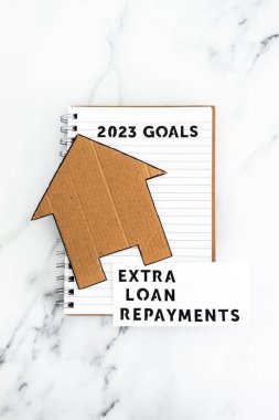 Yeni yıl 2023 hedefleri karton ev ve ekstra kredi ödemeleri metni, finansal bağımsızlık kavramı ve borçtan arınmış olmak.