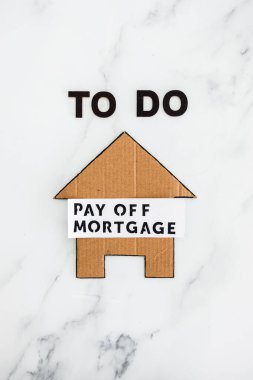 To Do Pay Off Mortgage text with cardboard house, concept of financial independence and being free from debt clipart