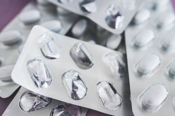 крупным планом поливитаминов или лекарственных таблеток в блистерные пакеты рядом с другими пустыми, концепция медицинского рецепта и пищевых добавок