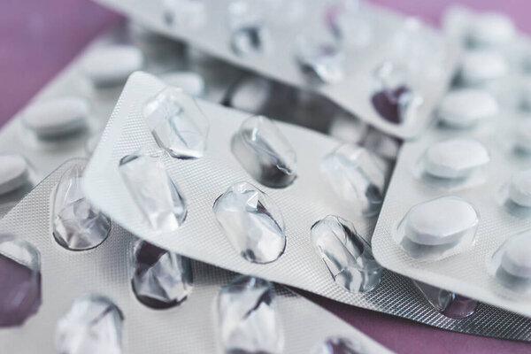 крупным планом поливитаминов или лекарственных таблеток в блистерные пакеты рядом с другими пустыми, концепция медицинского рецепта и пищевых добавок