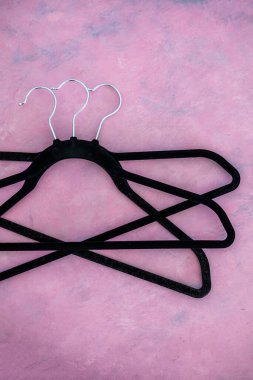 moda ve alışveriş konsepti, bir grup elbise askısı pembe arka planda geometrik şekil yaratıyor