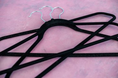 moda ve alışveriş konsepti, bir grup elbise askısı pembe arka planda geometrik şekil yaratıyor