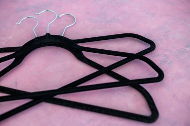 moda ve alışveriş konsepti, bir grup elbise askısı pembe arka planda geometrik şekil yaratıyor