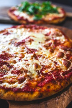Tahta tepside vejetaryen margherita ve roket pizzaları, sağlıklı yemek tarifleri.