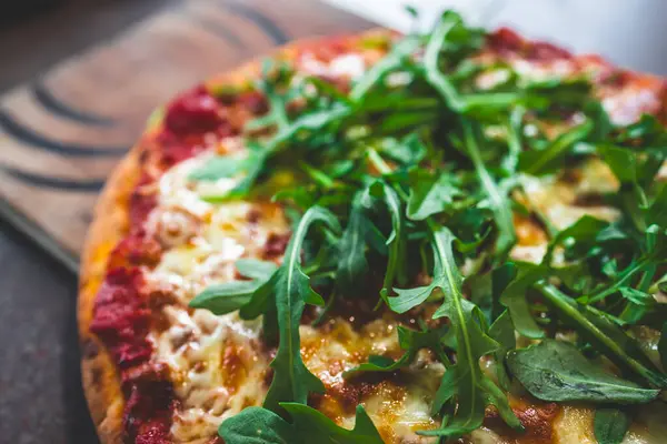 Tahta tepside vejetaryen margherita ve roket pizzaları, sağlıklı yemek tarifleri.