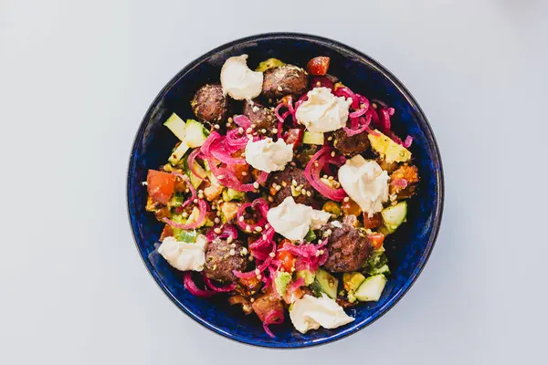 plant-based falafel nourish bowl salad with avocado tomato cucmber and pickled onion, healthy vegan food recipes