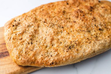 Biberiye ve tuz taneli ev yapımı Focaccia ekmeği, sağlıklı vegan yemek tarifleri.