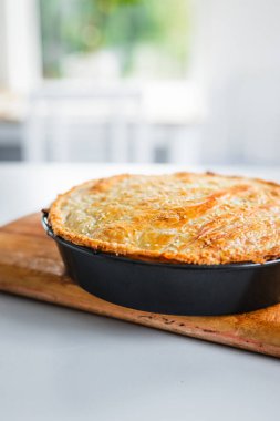homemade round puff pastry pie in style of a sheperd's pie with sesame seeds topping just out of the oven, healthy food recipes