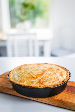 homemade round puff pastry pie in style of a sheperd's pie with sesame seeds topping just out of the oven, healthy food recipes