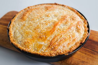homemade round puff pastry pie in style of a sheperd's pie with sesame seeds topping just out of the oven, healthy food recipes
