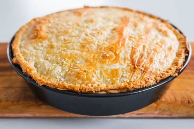 homemade round puff pastry pie in style of a sheperd's pie with sesame seeds topping just out of the oven, healthy food recipes