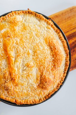 homemade round puff pastry pie in style of a sheperd's pie with sesame seeds topping just out of the oven, healthy food recipes