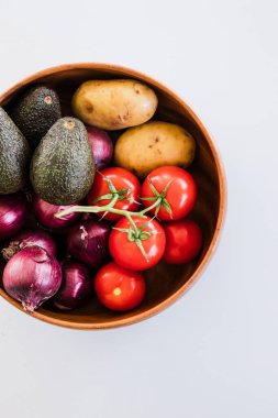 domatesli meyve kasesi patates avokadosu ve kırmızı soğan, sade sağlıklı malzemeler kavramı.
