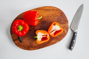 Tahta kesim tahtasında taze kırmızı dolma biber, sade ve sağlıklı malzemeler kavramı.