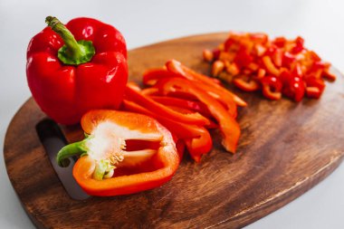Tahta kesim tahtasında taze kırmızı dolma biber, sade ve sağlıklı malzemeler kavramı.