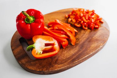 Tahta kesim tahtasında taze kırmızı dolma biber, sade ve sağlıklı malzemeler kavramı.