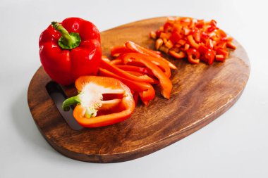 Tahta kesim tahtasında taze kırmızı dolma biber, sade ve sağlıklı malzemeler kavramı.