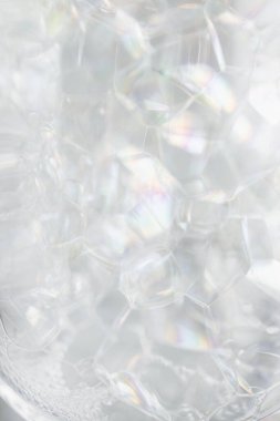 Cam şişe kabının içinde sabun deterjanı köpüklerinin yakın plan çekimi.