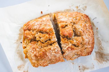 Pişirme kağıdında ikiye bölünmüş ev yapımı ekmek. Basit, sağlıklı malzemeler kavramı.