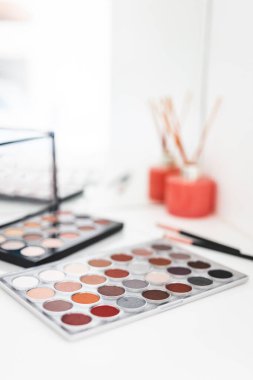 Göz farı paletleri çıplak tonlar ile makyaj masasında ayna ile, sığ alan derinliği, güzellik ve makyaj konsepti çekim
