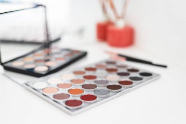 Göz farı paletleri çıplak tonlar ile makyaj masasında ayna ile, sığ alan derinliği, güzellik ve makyaj konsepti çekim