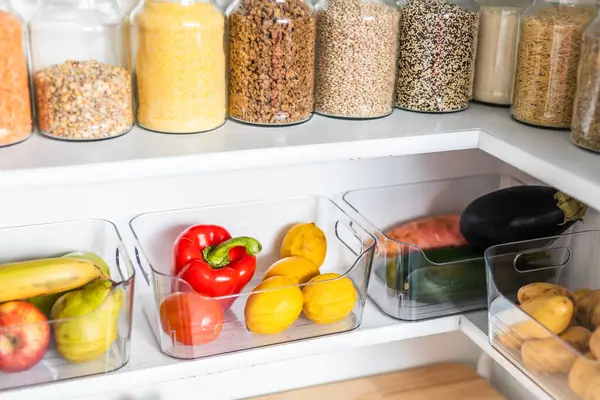 Taneciklerle, baklagillerle, baharatlarla ve konteynırlarda taze ürünlerle dolu, sağlıklı beslenme, düzenli ev, organizasyon ve düşüşle dolu küçük, düzenli bir kiler.