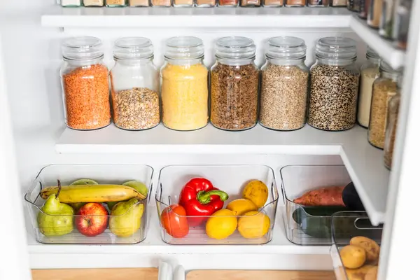 Taneciklerle, baklagillerle, baharatlarla ve konteynırlarda taze ürünlerle dolu, sağlıklı beslenme, düzenli ev, organizasyon ve düşüşle dolu küçük, düzenli bir kiler.