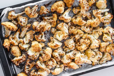 Kızardıktan sonra büyük bir tepside baharatlı taze karnabahar, ev yemeği ve yemek hazırlığı.