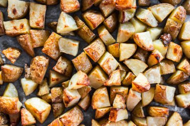 Kızardıktan sonra büyük bir tepside doğranmış bebek patatesler, sağlıklı yemek hazırlığı, temiz yemek ve ev yemeği gösteriliyor.