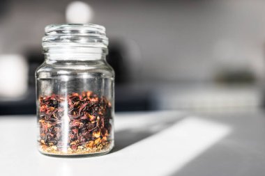 Mutfak tezgahındaki cam kavanozda kurumuş yaprak çayı. Doğal sağlığı, tadı ve mayalanmayı temsil ediyor.