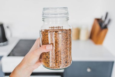 Mutfak tezgahının önünde el yapımı cam bir kavanoz sebze proteini (susuz soya), sıfırdan pişirme konsepti ve organize bir kiler.