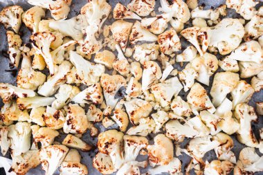 Kızarmış karnabahar çiçekleri fırın tepsisine yayılmış, vejetaryen tarifleri, temiz yemek ve yemek hazırlama temaları.