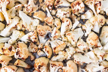 Kızarmış karnabahar çiçekleri fırın tepsisine yayılmış, vejetaryen tarifleri, temiz yemek ve yemek hazırlama temaları.