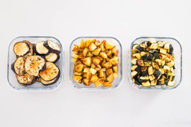 Kavrulmuş patates, kabak ve patlıcan dilimleri ile dolu cam kaplar sağlıklı vejetaryen yemeği hazırlamak ve temiz yemek temaları için mükemmel.