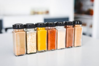 Cam kavanozlar dolusu sarımsak, soğan, zerdeçal, kırmızı biber, zencefil, garam masala ve Çin baharatı mutfak tezgahına dizilmiş, yemek pişirme, yemek hazırlama ve mutfak teması için mükemmel.