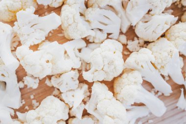 Kırsal ahşap kesim tahtasında taze doğranmış karnabahar, sağlıklı tarifler, diyabet dostu yemek hazırlama ve bitki bazlı yemek temaları